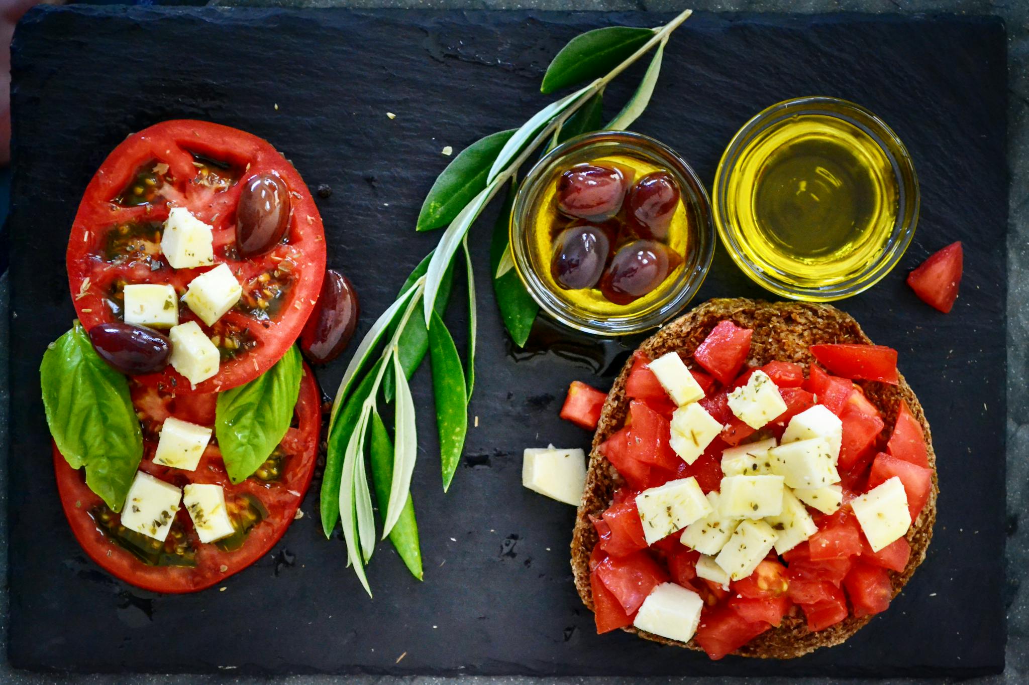 A vibrant Greek salad featuring tomatoes, feta, and olives on a slate board, perfect for healthy eating.