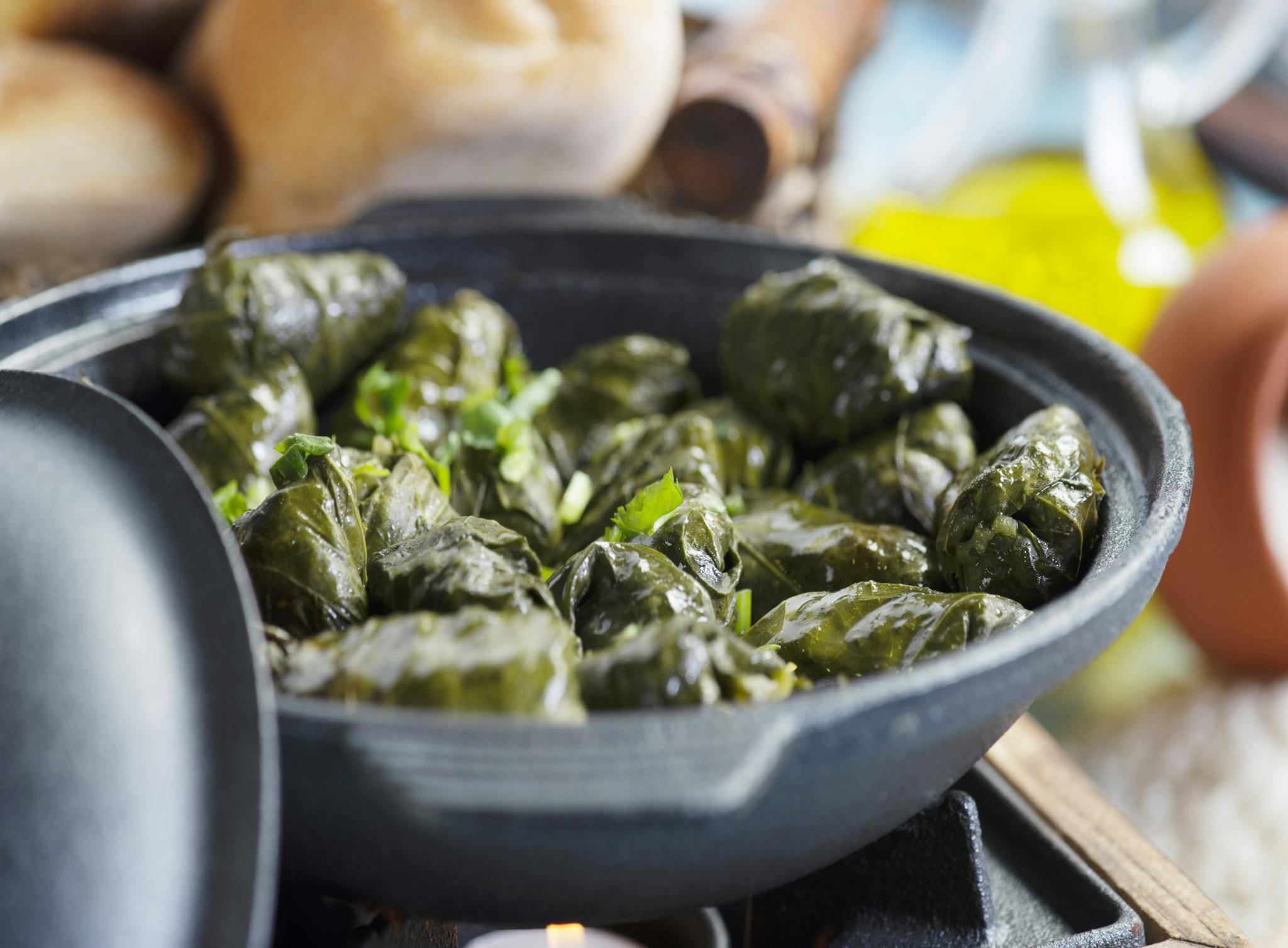 Delicious stuffed grape leaves served in a ceramic dish, perfect for a Mediterranean meal.