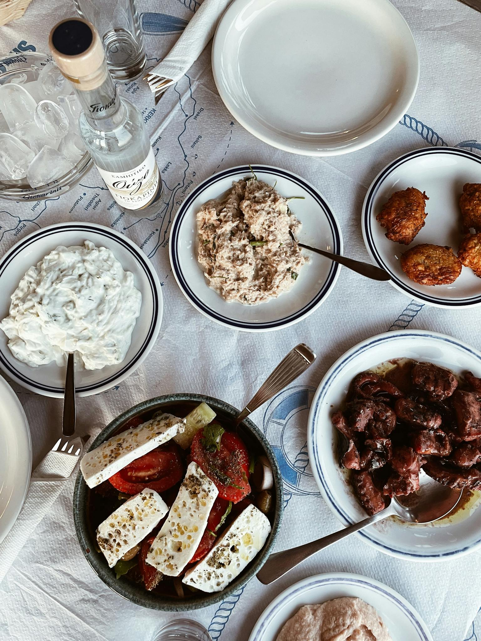 Explore a traditional Greek meal setting with diverse dishes in Pefkos, capturing the essence of culinary delight.