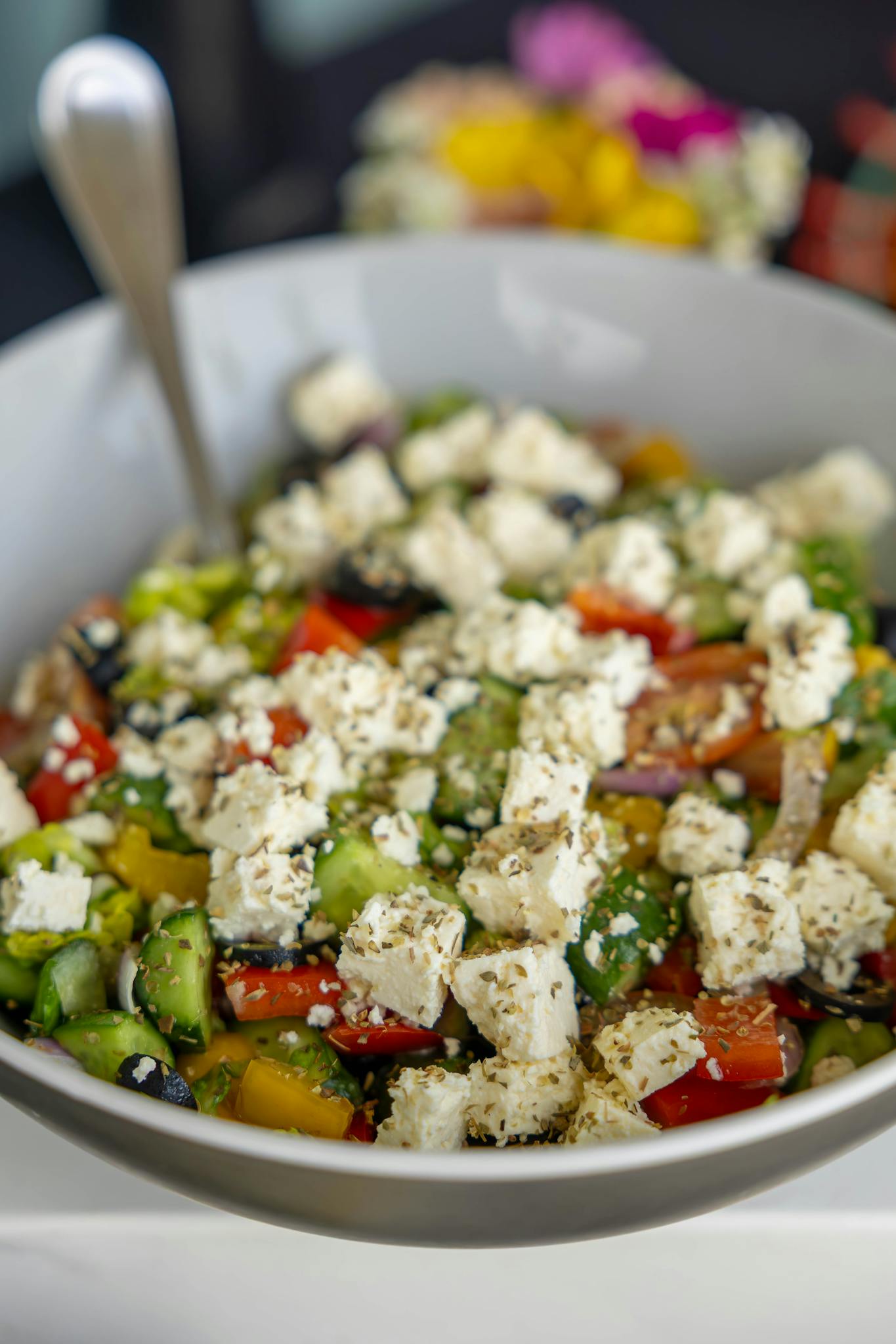 Vibrant Greek salad featuring fresh veggies, olives, and feta cheese cubes.